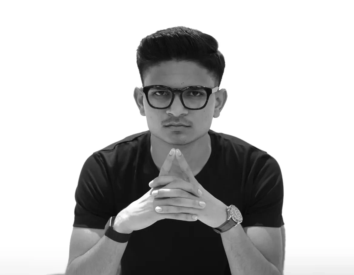 Ramsingh Vaghelaa, seated, hands steepled, in a black-and-white studio portrait